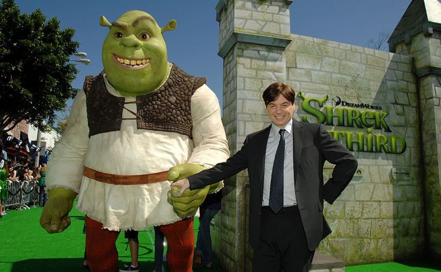 Mike Myers holding hands with a lifesized Shrek statue