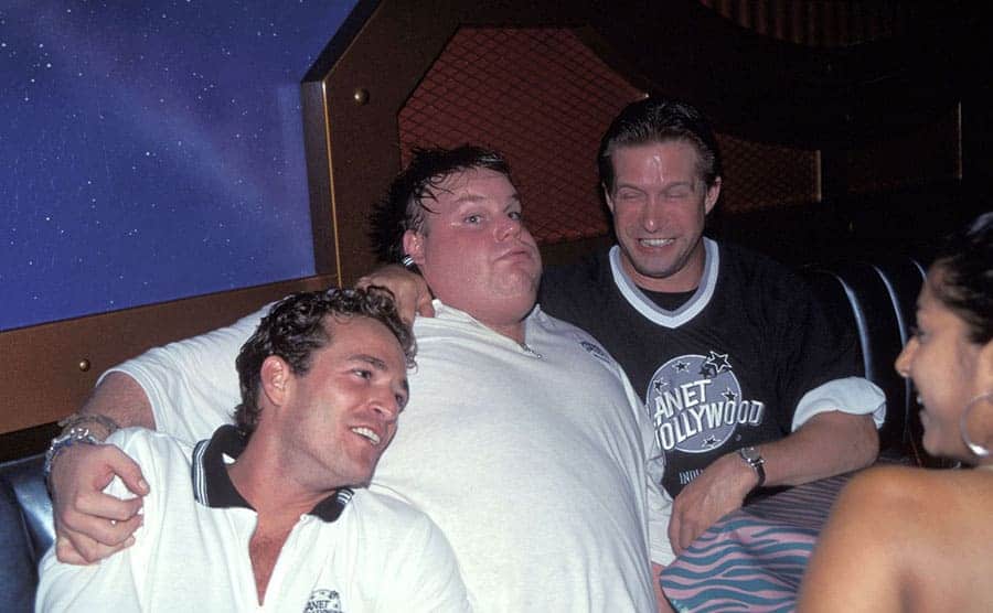 Luke Perry, Chris Farley, and Stephen Baldwin sitting around a table drunk at the Planet Hollywood opening in New York
