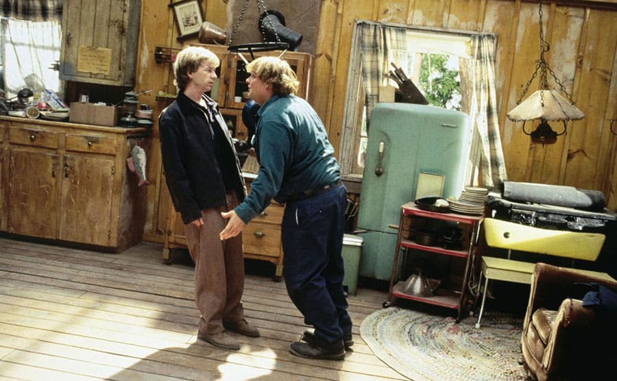 David Spade and Chris Farley talking in a slanted cabin in a scene from Black Sheep