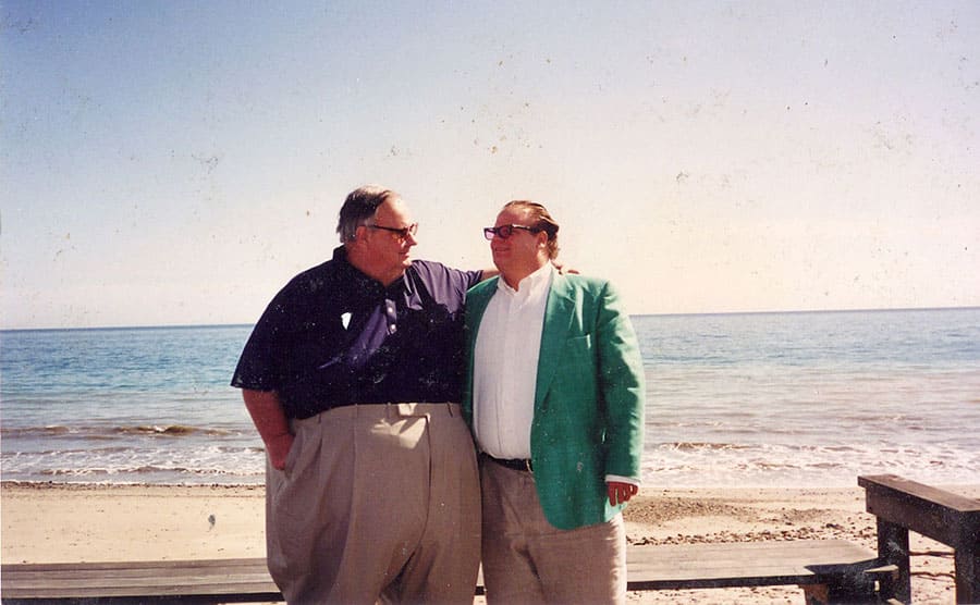 Chris Farley with his father posing in front of the ocean
