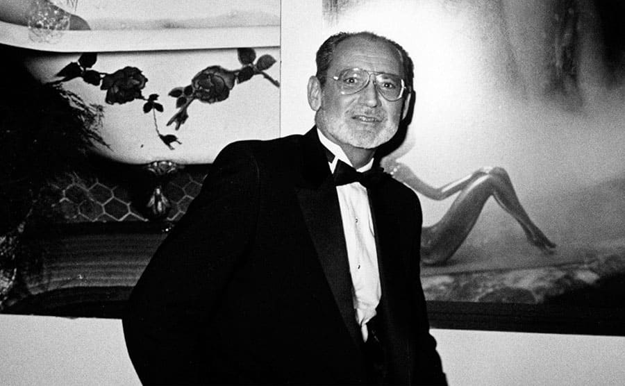 Garry Gross posing in front of his photographs