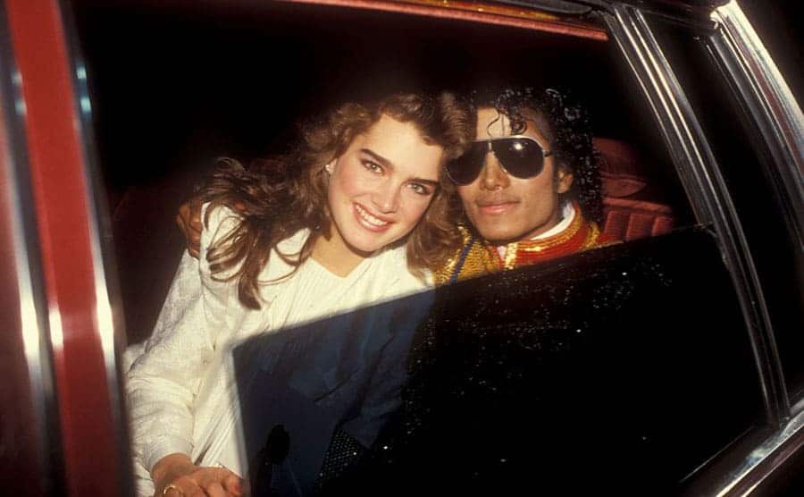 Brooke Shields and Michael Jackson smiling in the backseat of a car