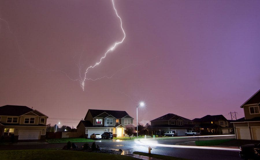 Lightning storm over a residential neighborhood at night.