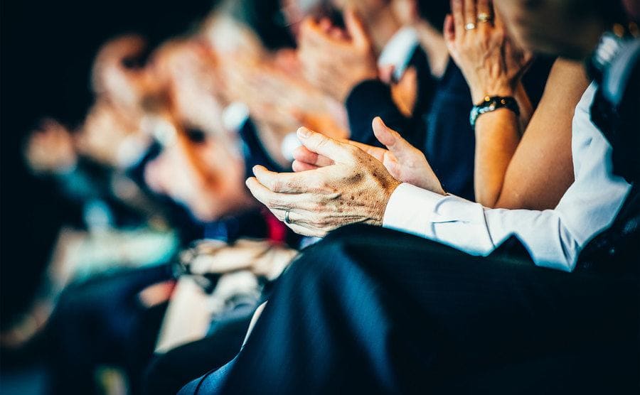 Hands of a crowd applauding at a conference. 