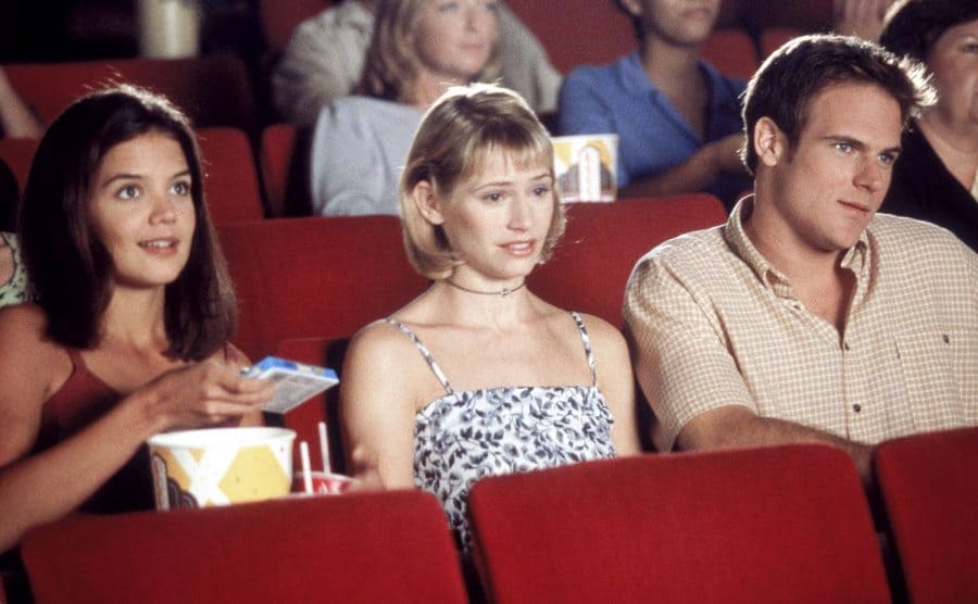 Katie Holmes, Meredith Monroe, and Nuklaus Lange sitting in a movie theater