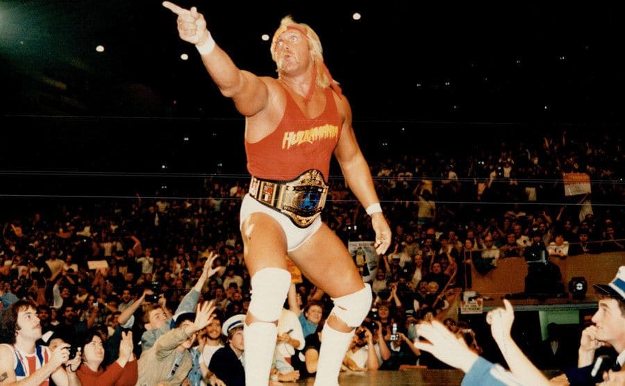 Hulk Hogan pointing out into a crowd of people while in a wrestling uniform 