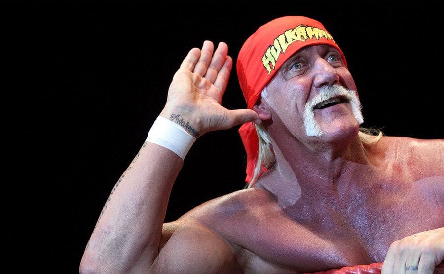 Hulk Hogan holding his hand near his ear to get a crowd ready 