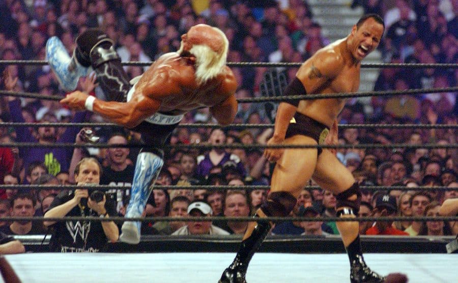 Hulk Hogan falling as Dwayne Johnson walks away from him 