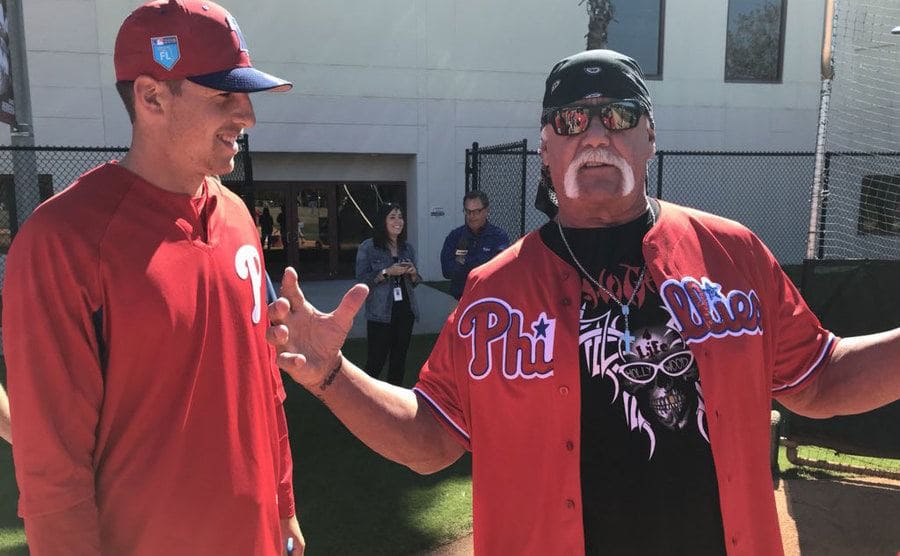 Hulk Hogan in a Phillies jersey on a baseball field 