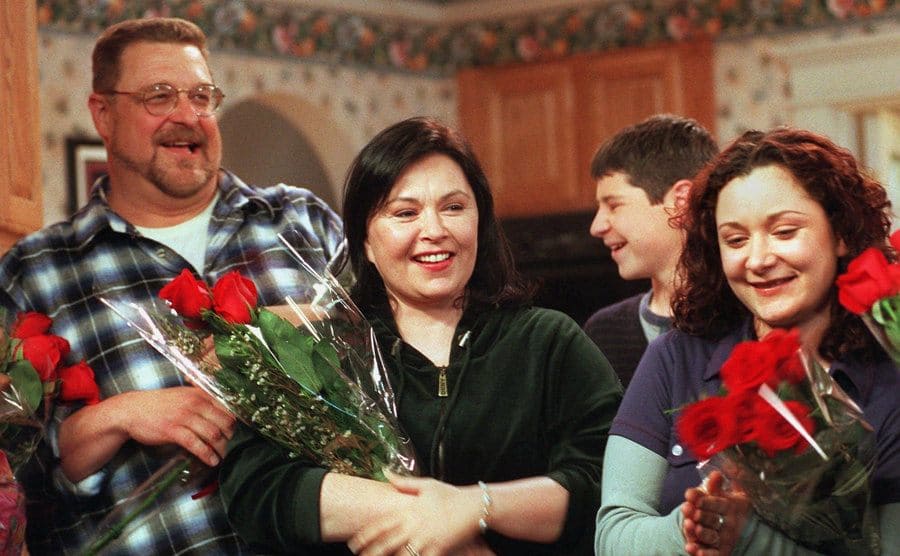 The cast of Roseanne holding roses 