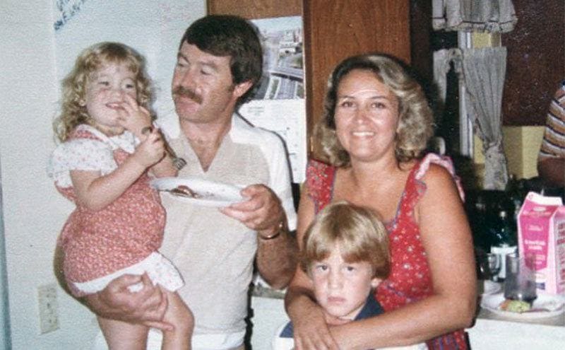 A family photo of Adair and his wife with their two children.