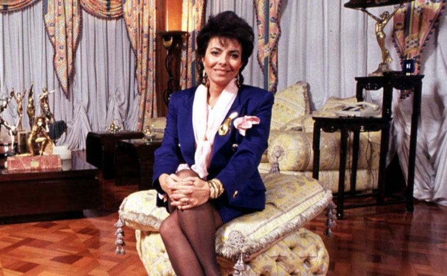 Patrizia Reggiani sitting in the living room of her fancy apartment. 