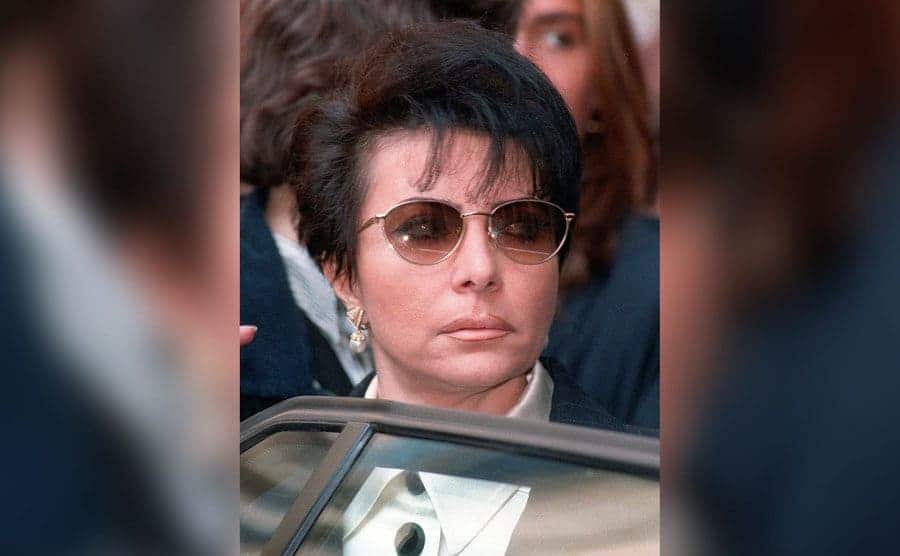 Patrizia Reggiani is entering a car with a look of contempt on her face. 