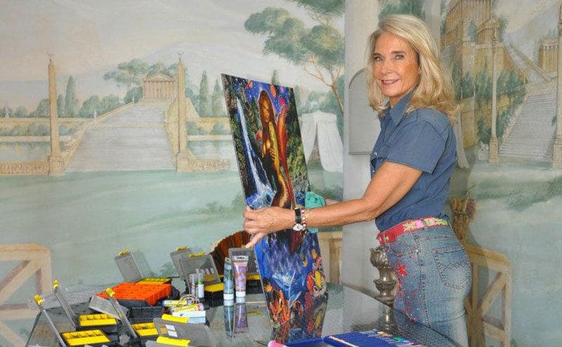 Paola Franchi in her home with her paintings. 