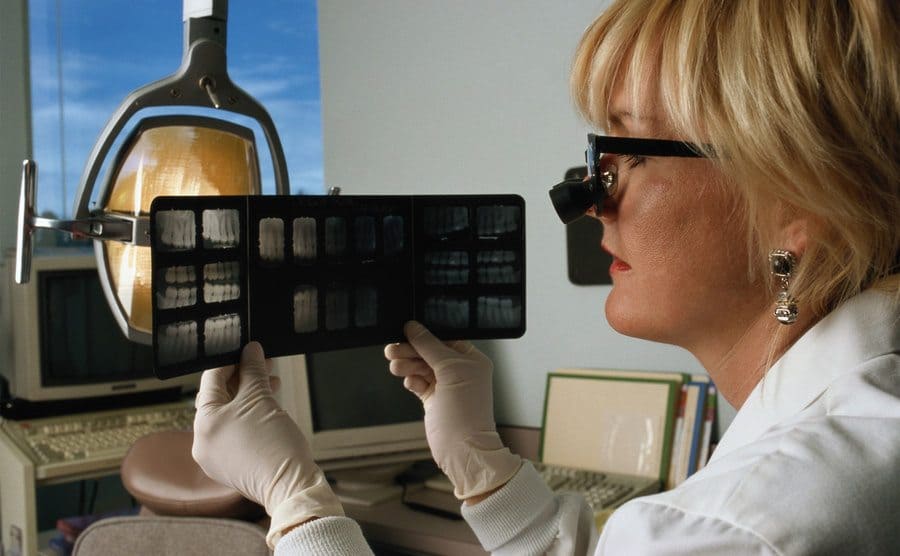 A dentist holds up dental X-rays to examine them.
