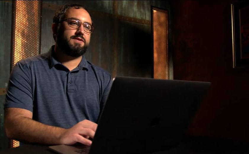 Kevin is sitting beside his computer looking up information.