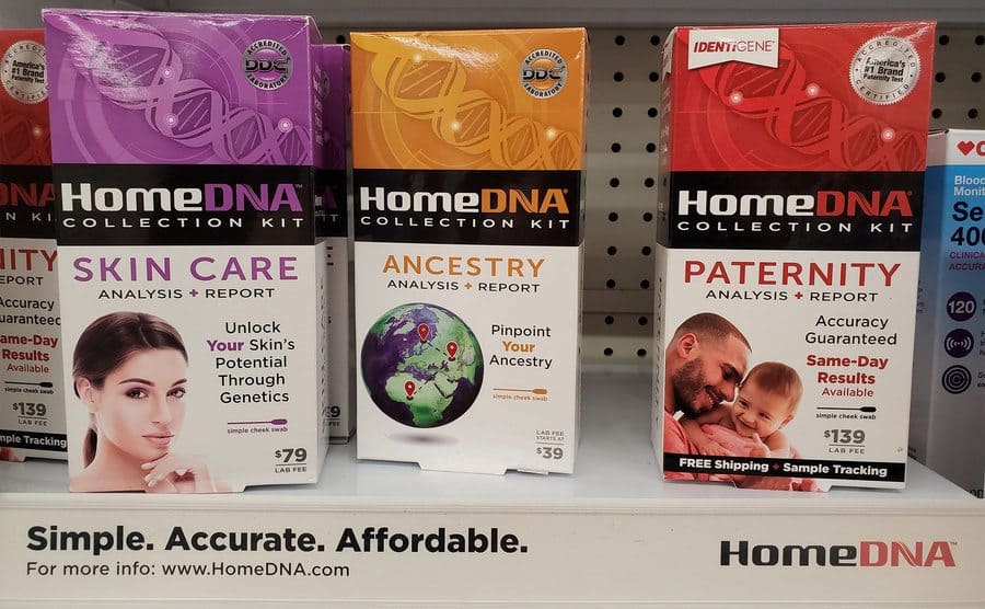 Close-up of HomeDNA kits, including testing for ancestry, skincare, and paternity, on a pharmacy shelf.