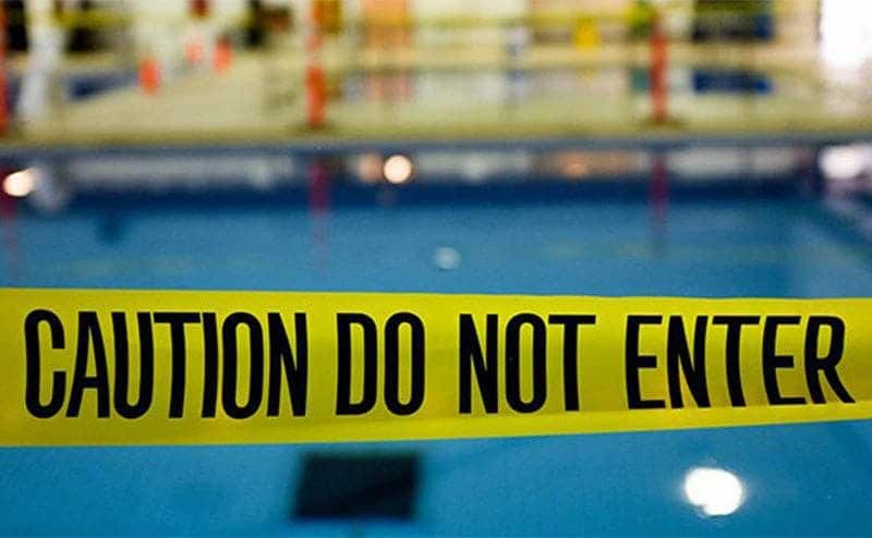 Police tape blocking the entrance to the pool.