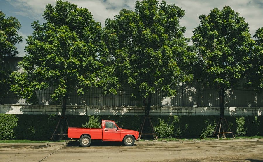 A red pickup truck is parked on the side of the road.