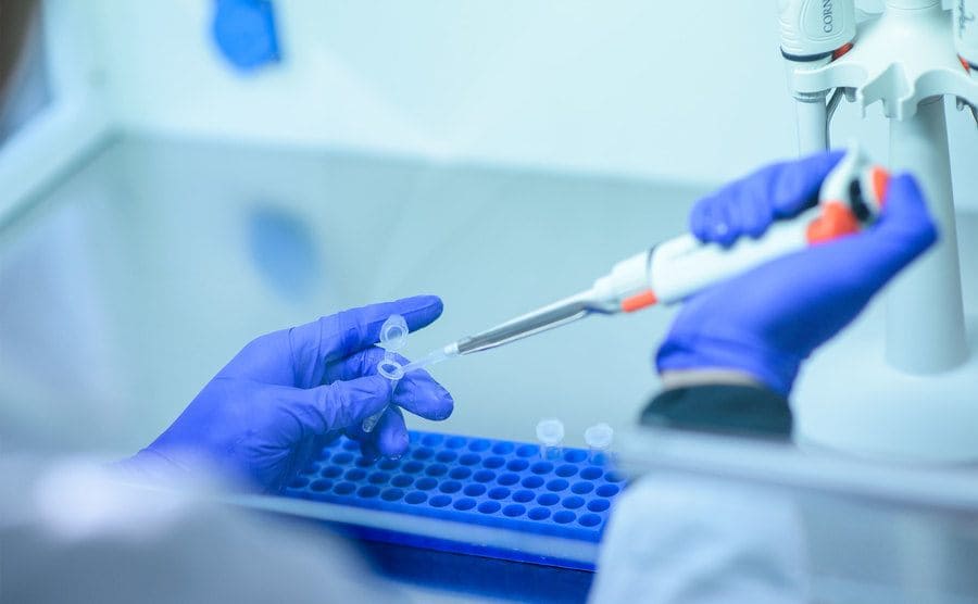 A lab technician is testing the DNA sample.