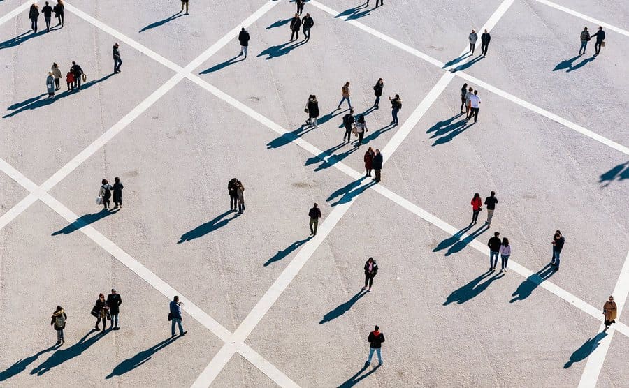 People walking in the town square on a sunny day.
