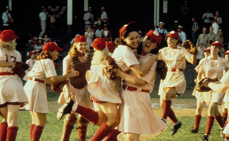 Rosie O’Donnell lifting Madonna in celebration as the rest of the team runs onto the field.