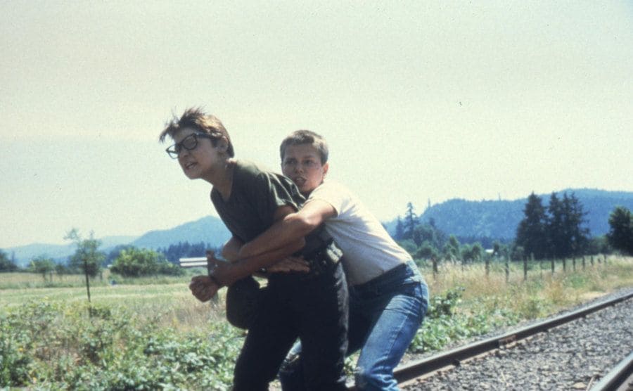 River Phoenix is holding back Corey Feldman in a still from ‘Stand By Me’.