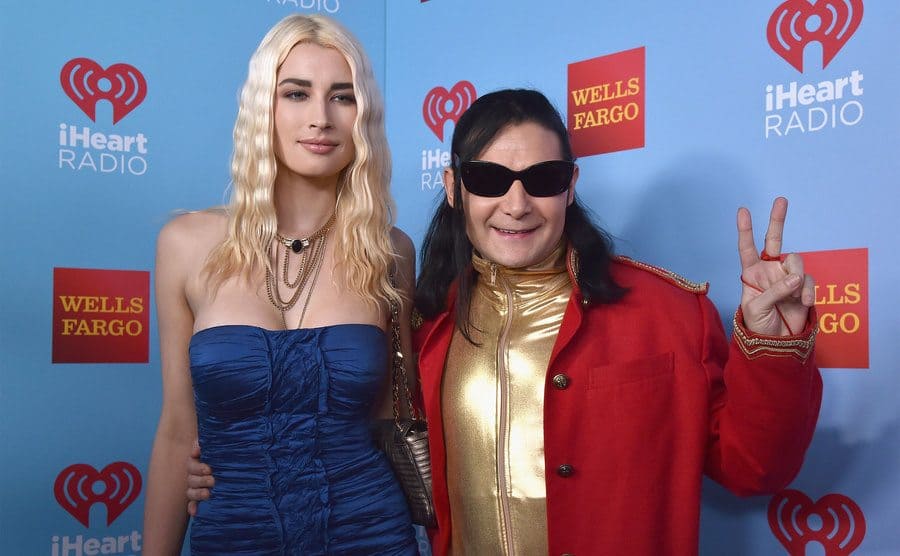 Courtney Anne Mitchell and Corey Feldman pose backstage during iHeart80s Party.