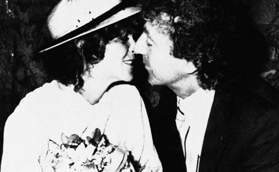 Gene leaning in to kiss Gilda on their wedding day.