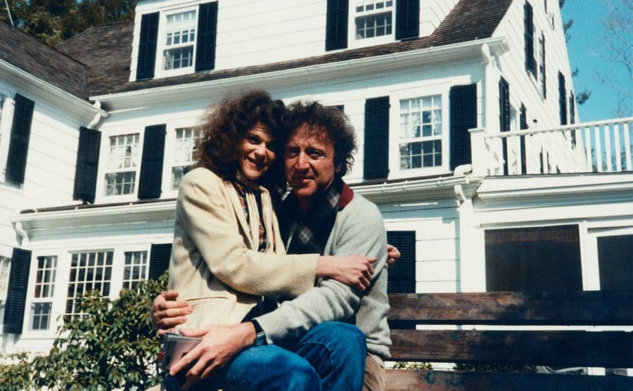 Gene and Gilda taking a photo outside their home.