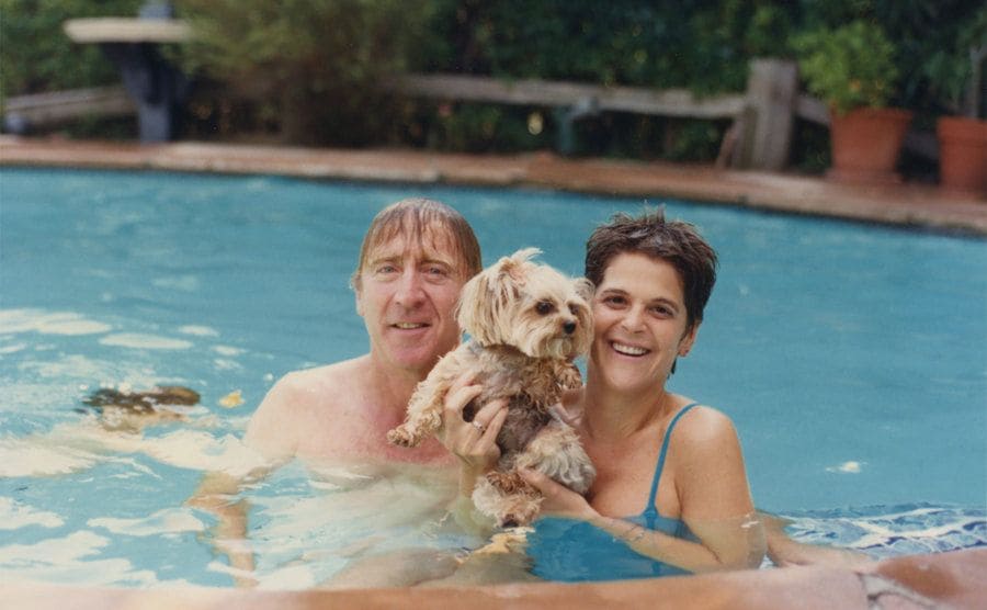Gene and Gilda are hanging out in the pool with their dog.