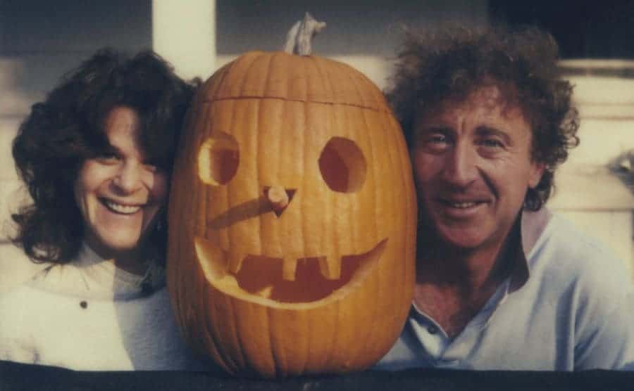 Gene and Gilda posing on their side of a carved jack-o-lantern.