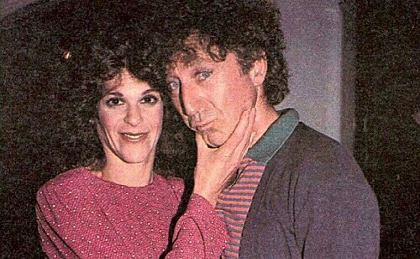 Gilda is pinching Gene’s cheeks.