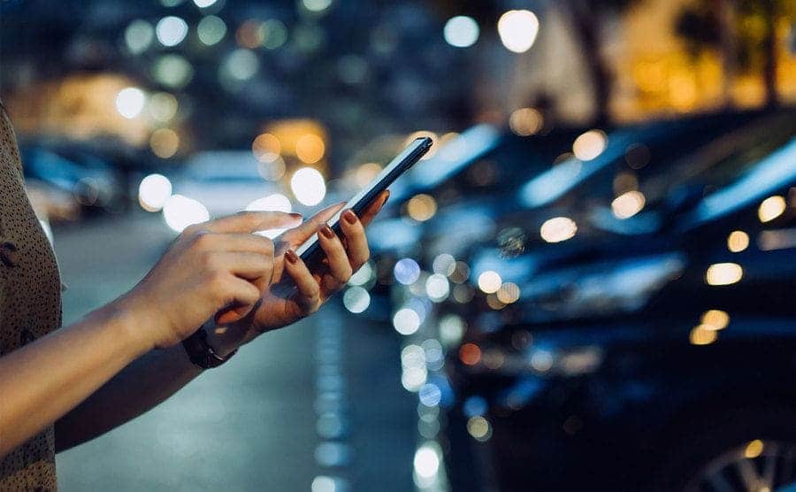 A woman is holding up her smartphone to make a call. 