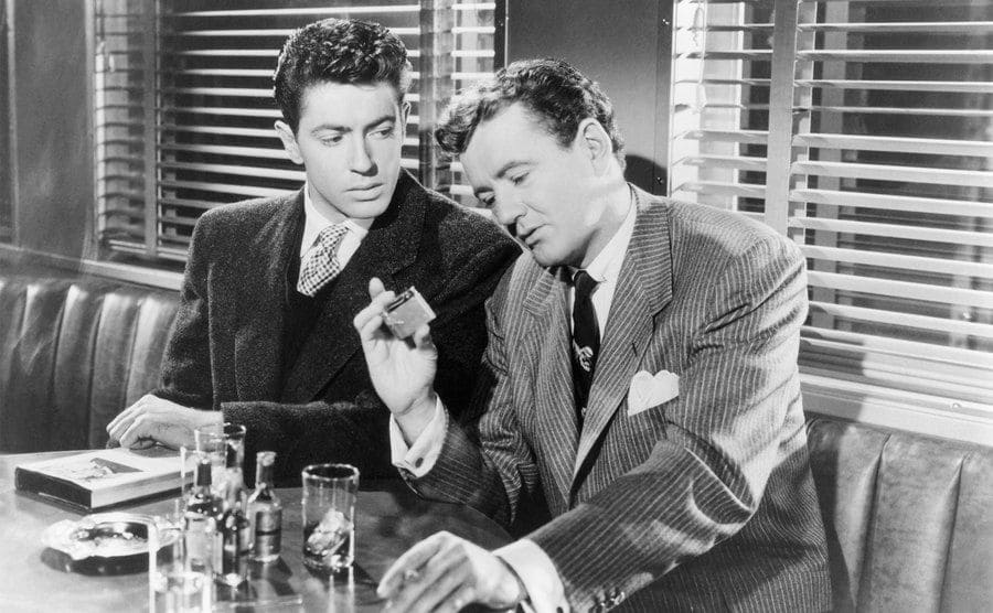 Robert Walker and Farley Granger hold up Guy’s lighter on the set of Strangers on a Train.