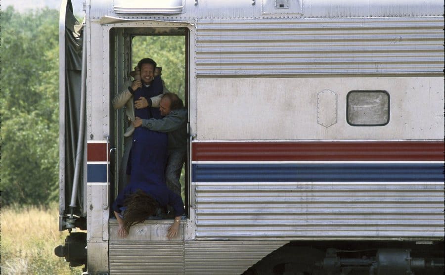 Cyystal and DeVito are trying to throw Anne Ramsey from the train, in a still from “Throw Momma from the Train”.