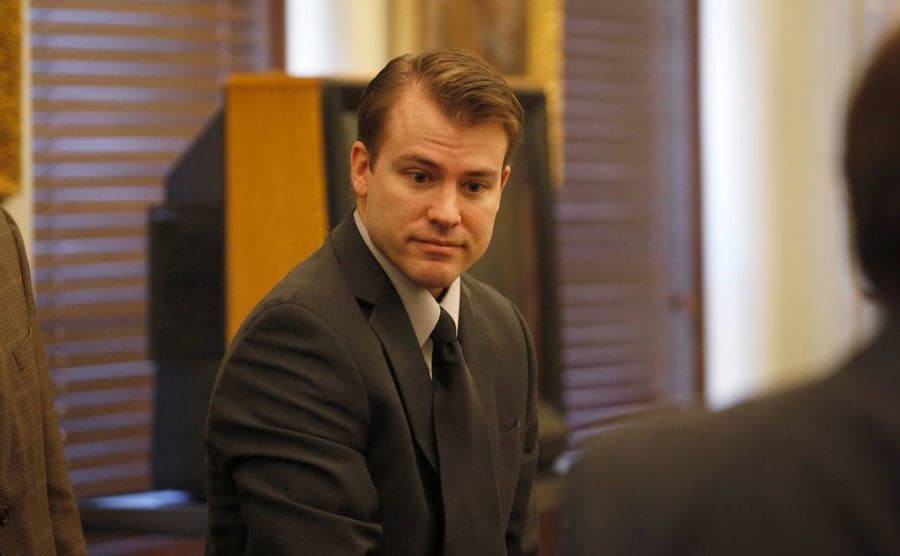 Portrait of Brett with a dazed expression while standing in the courtroom.
