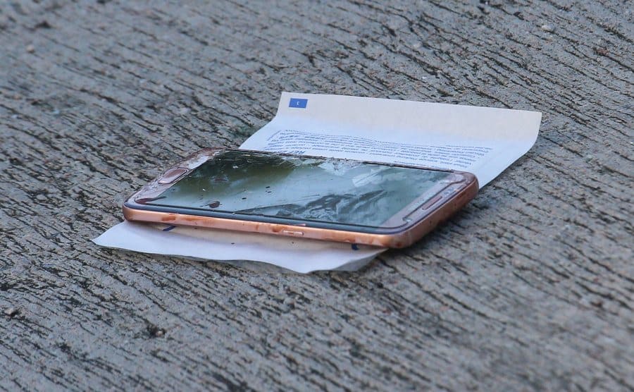 A broken mobile phone on the floor.