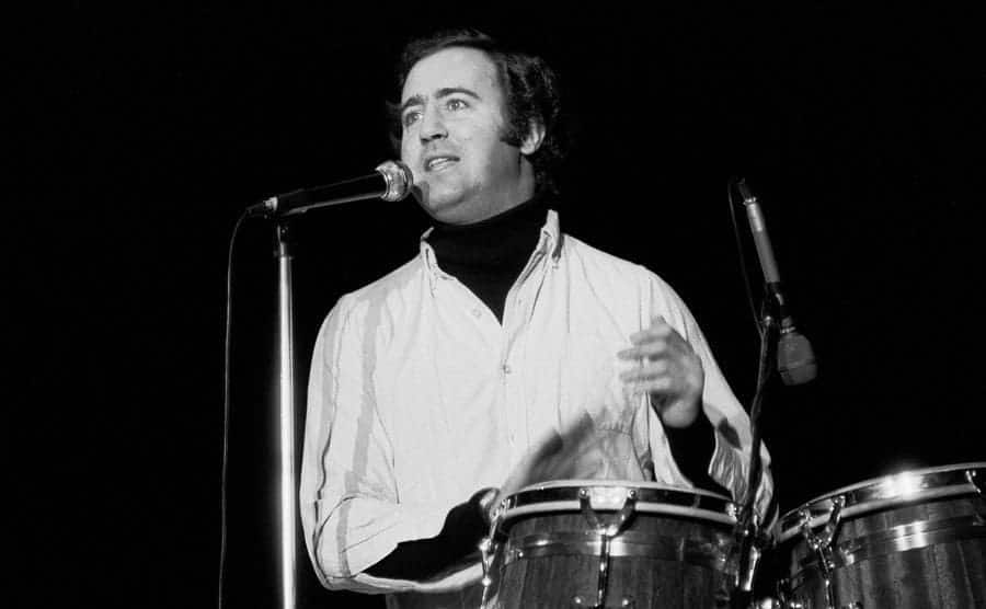 Andy Kaufman is performing on stage.