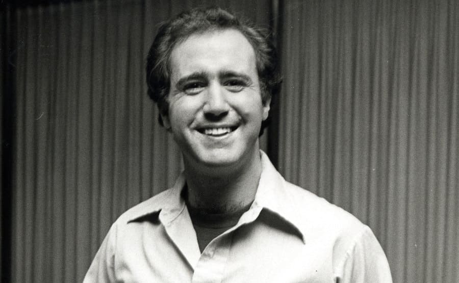 Andy Kaufman is smiling at the camera during the