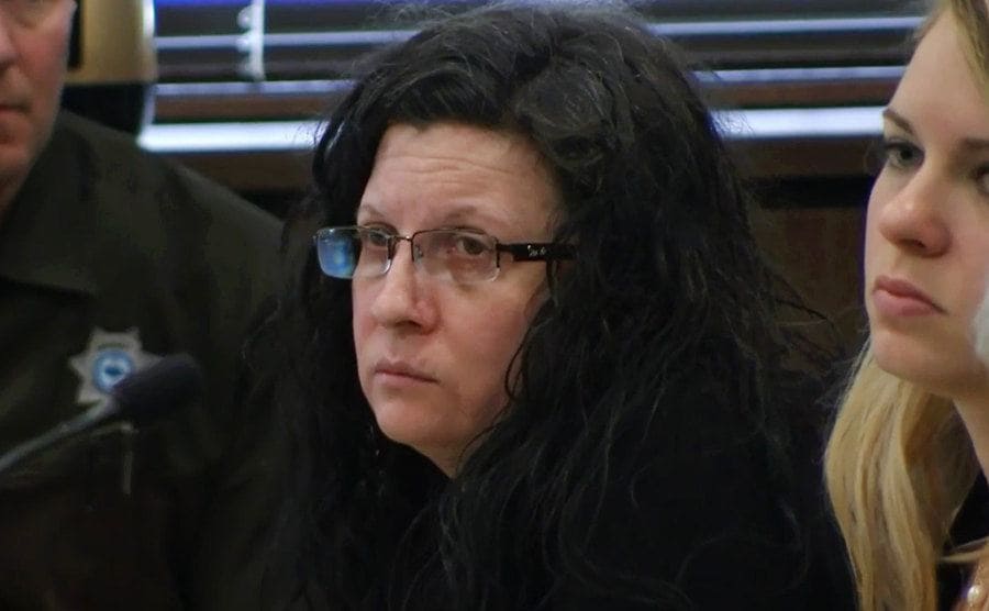 A still of Golyar sitting in the courtroom next to police officers.