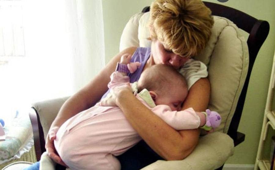 Cindy is holding newborn baby Caylee as she gently swings in a rocking chair.