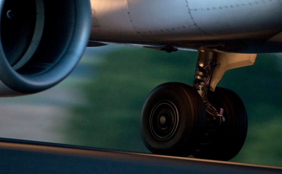 Airplane landing gear close-up rolling down the runway.