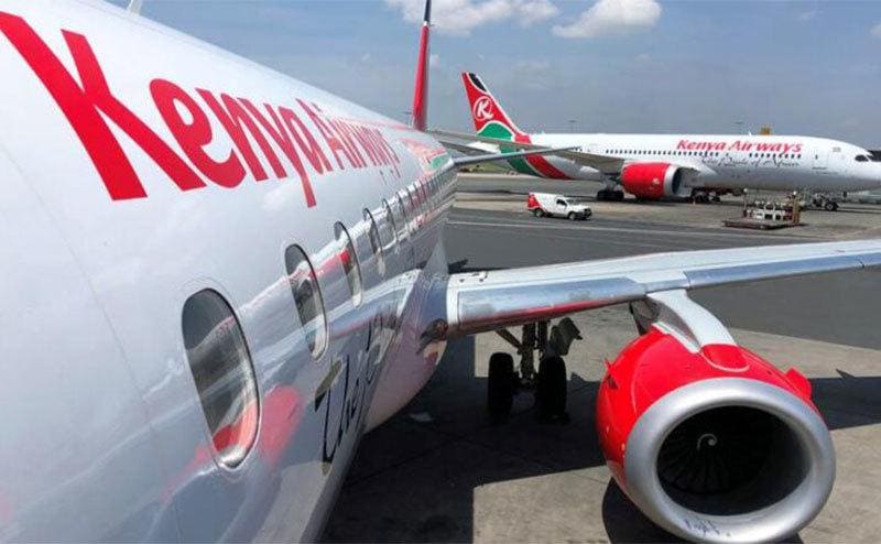 A Kenya Airways plane waits at the gate.