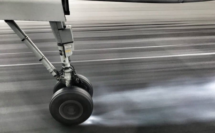 Plane wheels skid as they land on the tarmac.