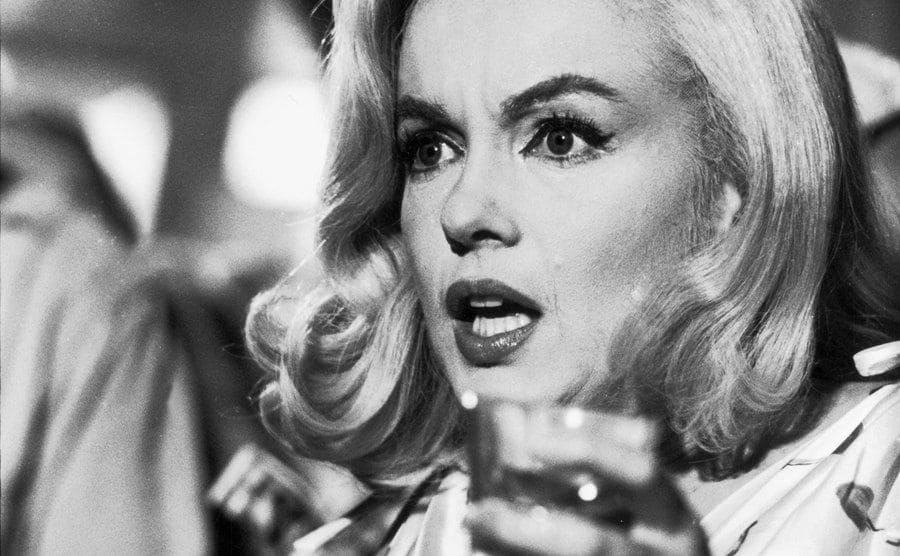 Marilyn Monroe walks holding a drink during the filming of ‘The Misfits.’
