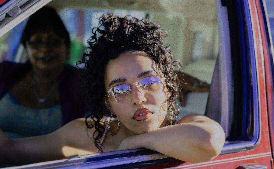 FKA Twigs gazes through the window car in Honey Boy.