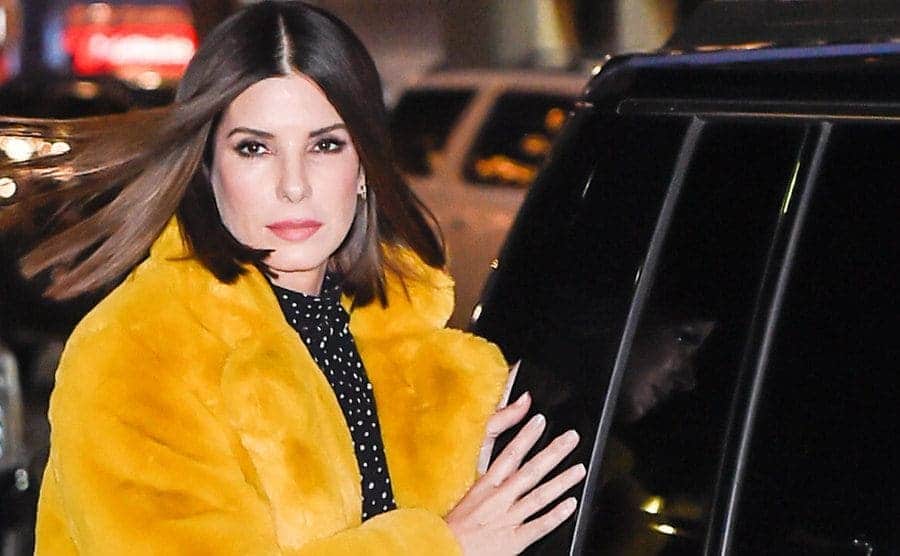 Sandra Bullock closes the back car door as she arrives at the theater.