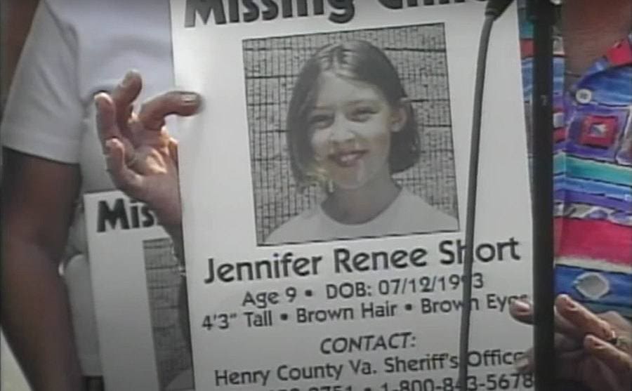 Hands are holding a missing poster of Jennifer Short.
