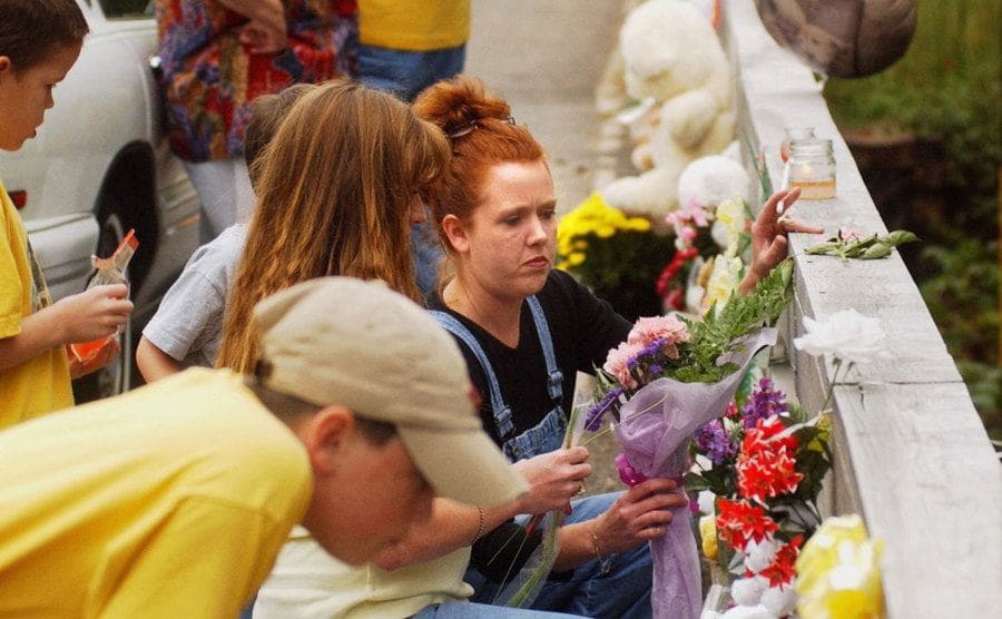 A woman places flowers near the site where Jennifer’s body was found.